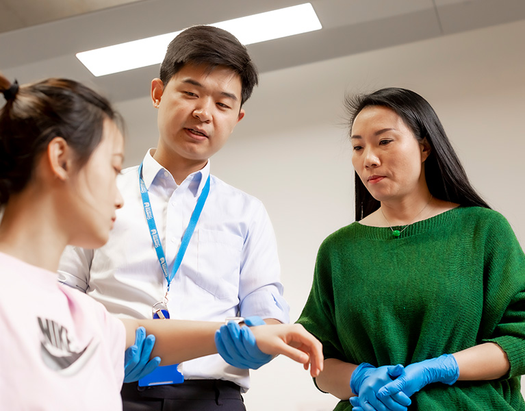 Three research students stood together talking