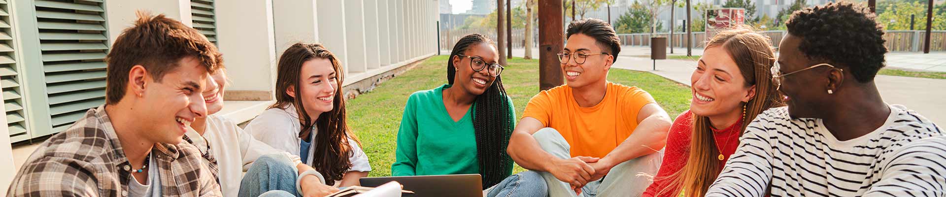 Group of students sitting outside in the sunshine