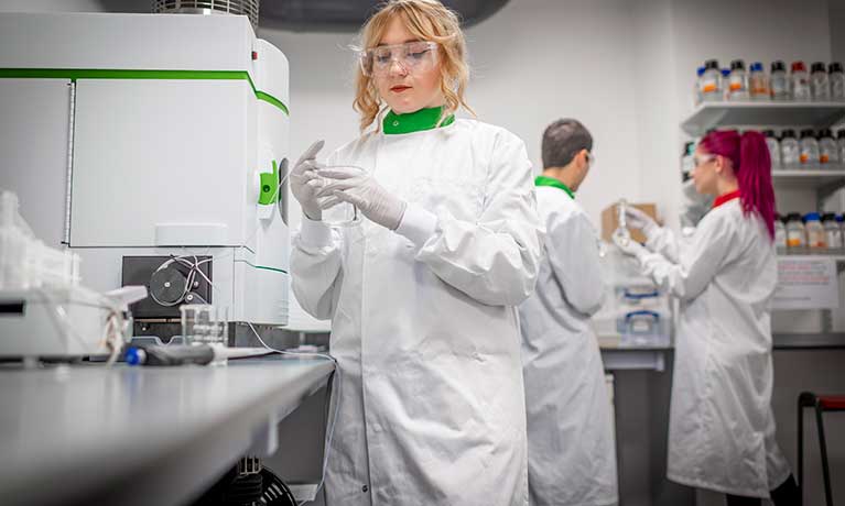 Students in Analytical Chemistry female student using a petri dish 