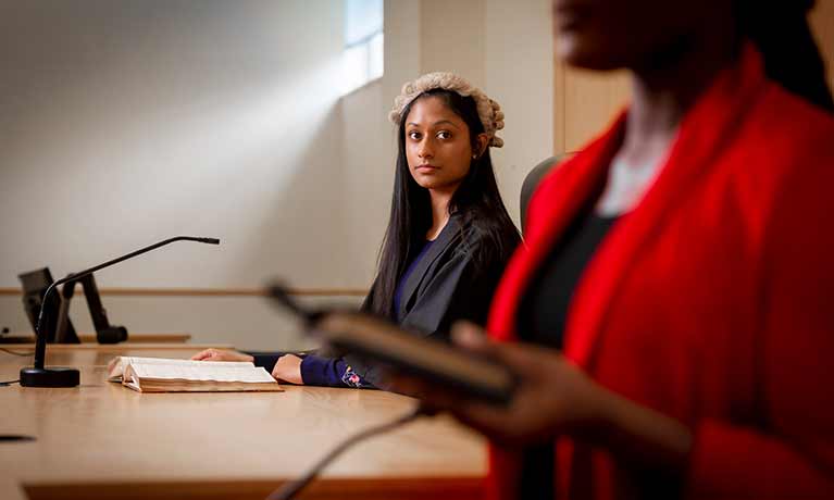 Two law students practicing, one is wearing a judge's wig