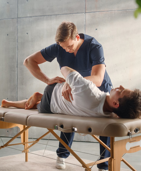 patient being treated by a physiotherapist on a therapy bed