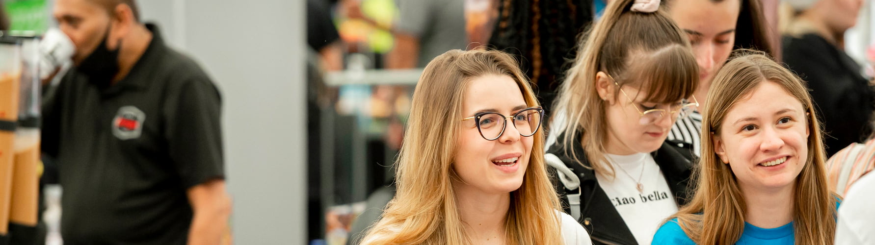 Female students wearing lanyards at a work fare