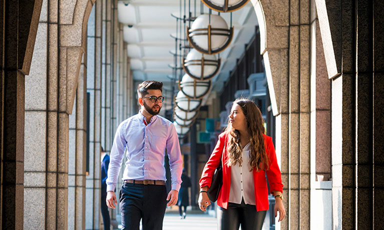 Two students walking through campus