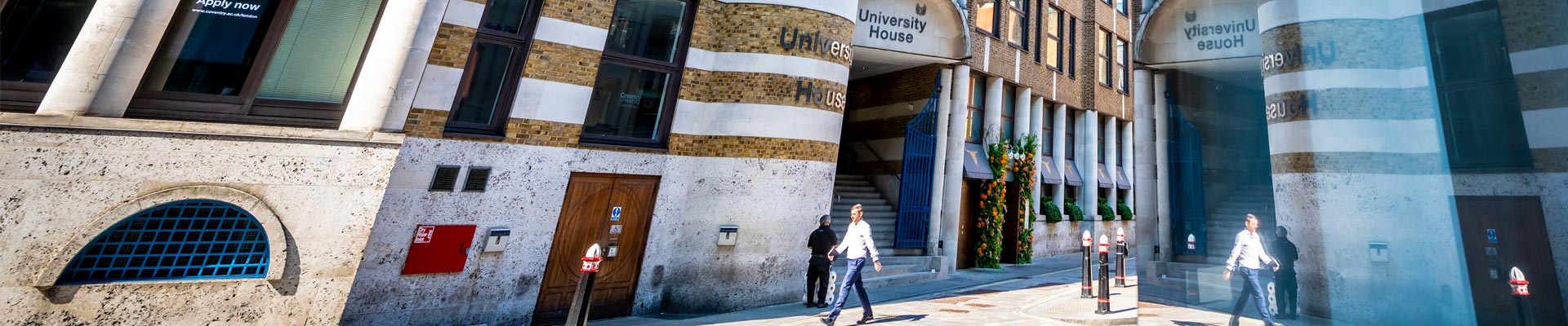 A man walking past Coventry University London's University House building on a bright sunny day