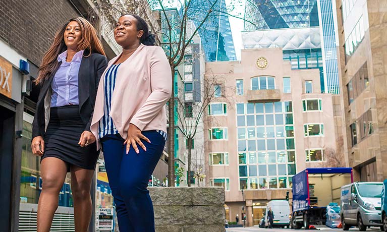 Two female students walking outside London Campus.