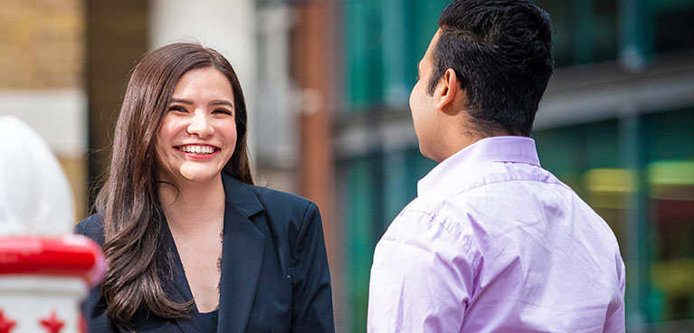 Two professionals chatting outside a building