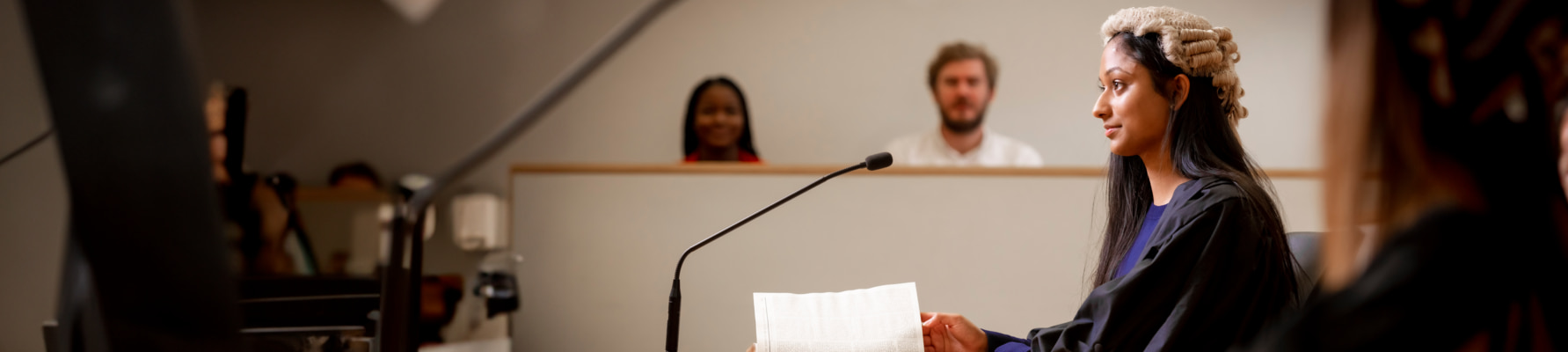 Female student wearing a judges wig in a mock court room