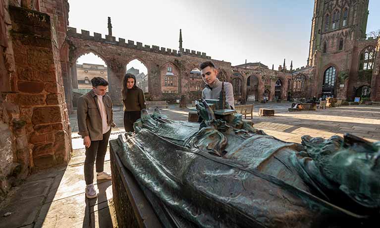 Three students in Coventry cathedral ruins