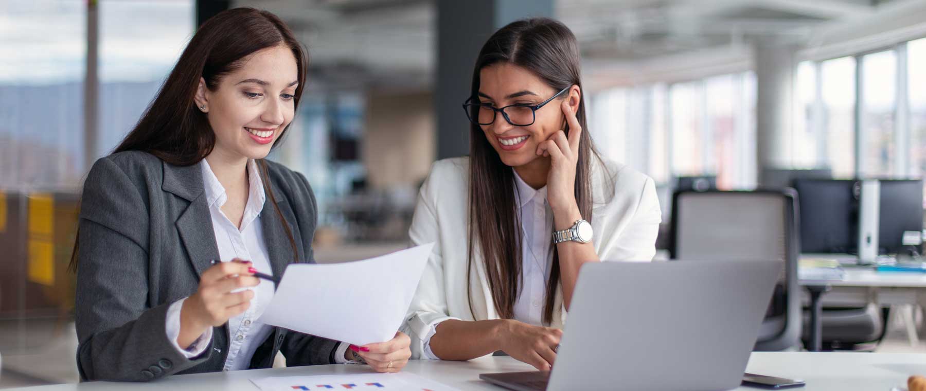 two women talking with laptop