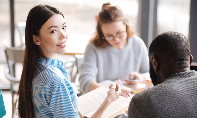 Three students sat at a table working