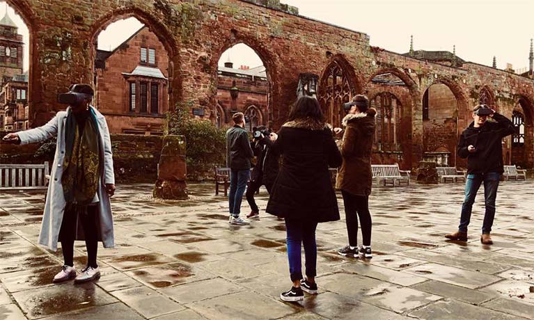 Group of people in Coventry Cathedral using VR goggles