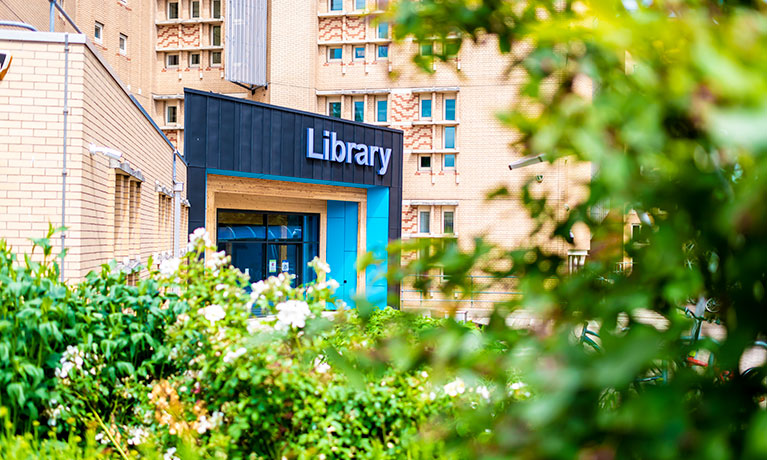 Entrance to the Lanchester Library surrounded by bright green leaves