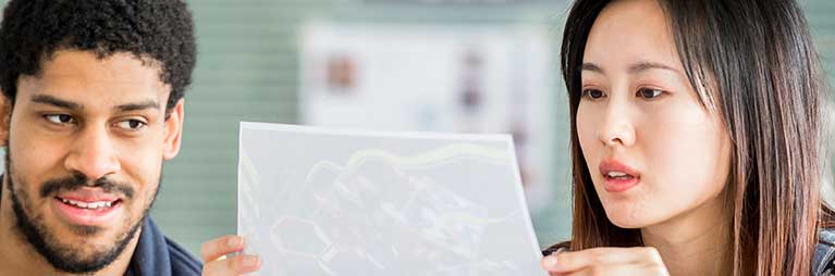 Two international students looking at an image.