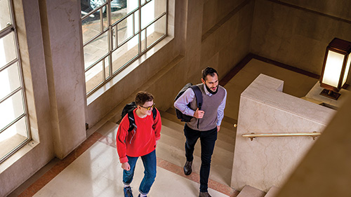 Two students walking through a hall at CU London Dagenham.