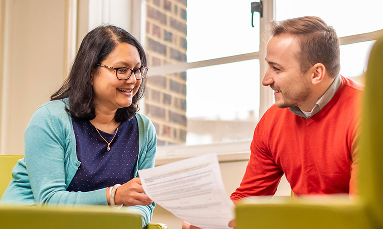 Two students looking at a document talking