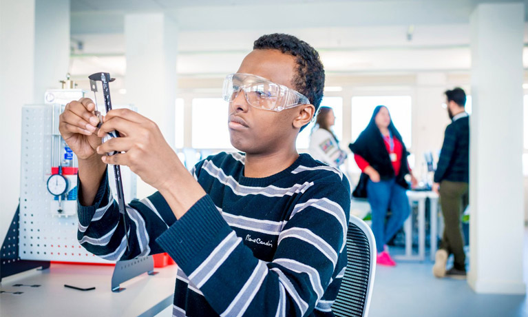 A student using engineering equipment.