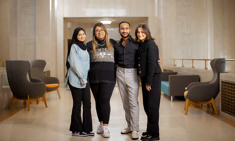 Four students stood together smiling