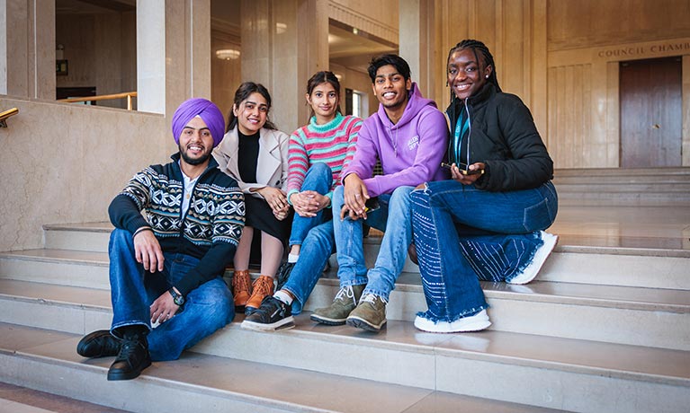 Students sitting together outside of a university building