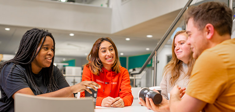 Group of students talking to each other around a table