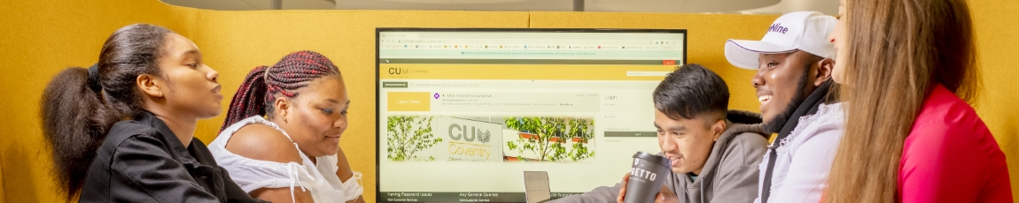 Group of students sat together with a PC screen in the background