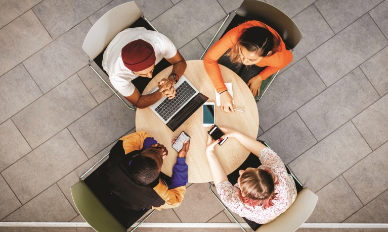 Birdseye view of four people around a small table