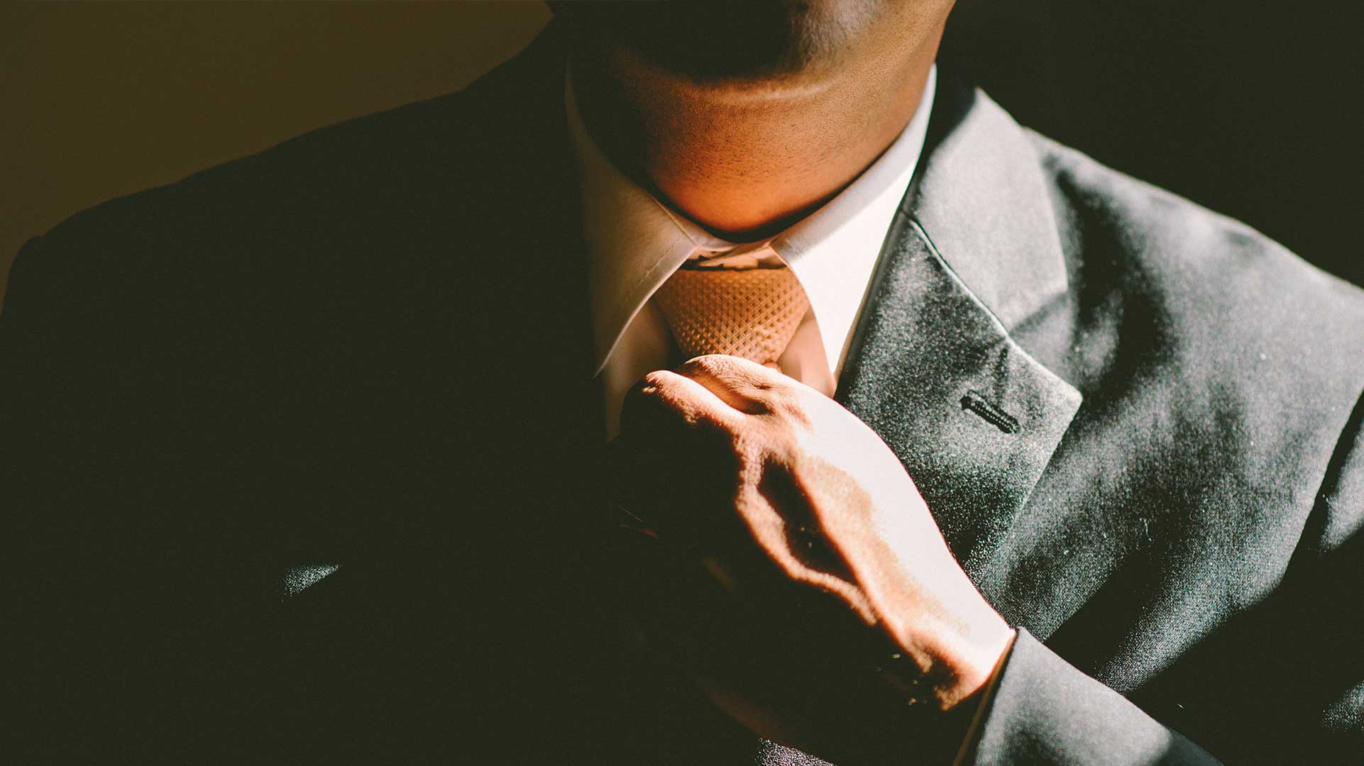 Business Management student adjusting a suit tie