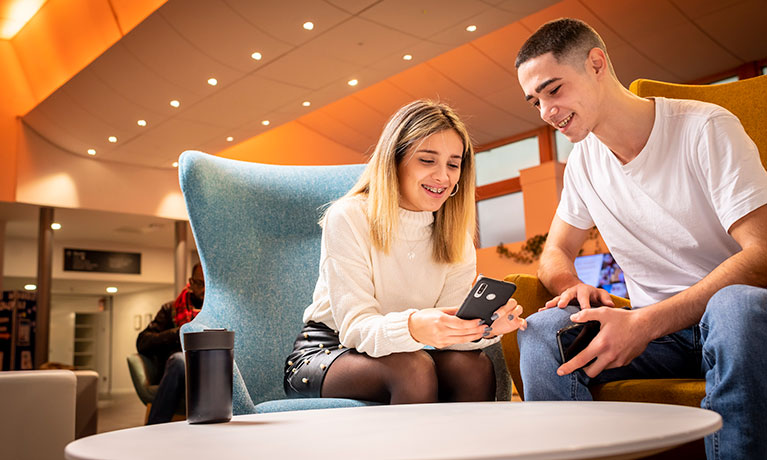 Group of students sat chatting in a learning pod at Coventry University