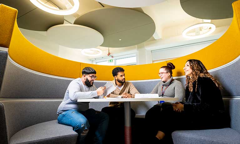 Four students sat in a soundproof pod talking