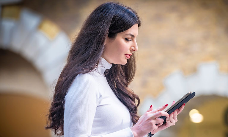 Lady wearing a white top reading a book