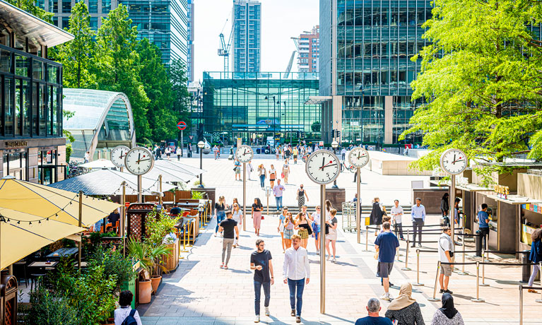 People walking through London square on a sunny day