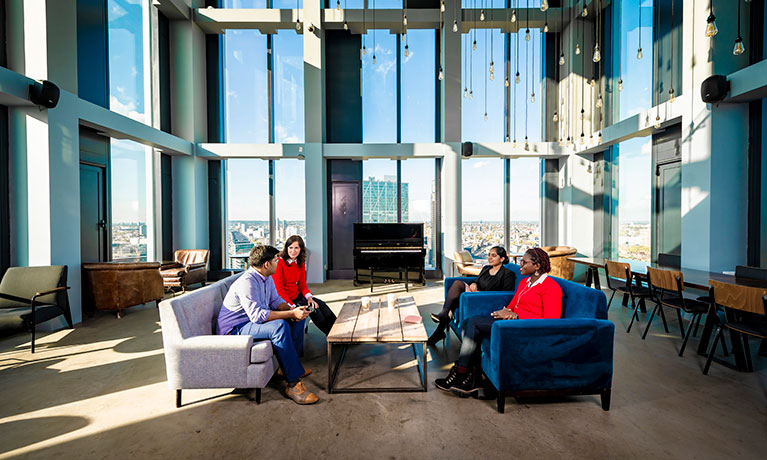 students chatting across sofas