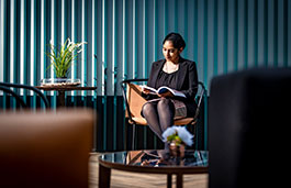 lady sitting in a dark room reading a book