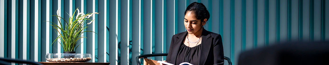 lady sitting in a dark room reading a book