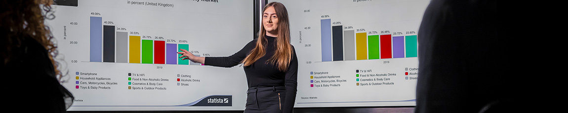 female presenting and pointing to charts