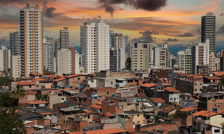 A landscape shot of a city showing shanty houses near to skyscrapers