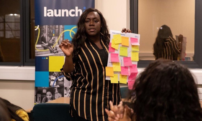 Lady presenting a poster to a group of people