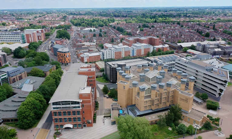 An aerial image of Coventry University's William Morris building and Lanchester Library with the Coventry city skyline in the background