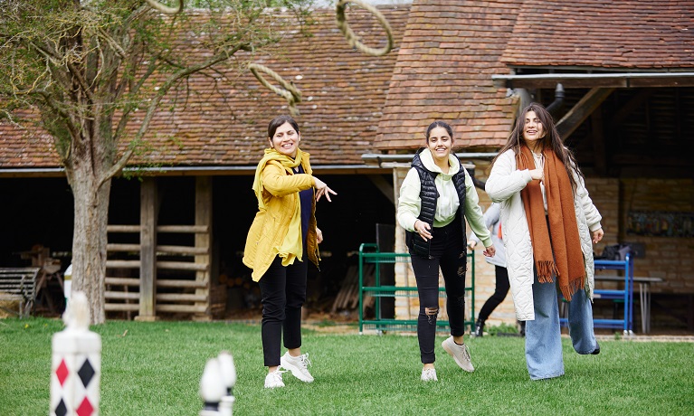 Three women throwing hoops at a target