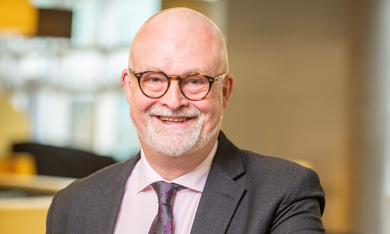 A head and shoulders image of Coventry University Provost Ian Dunn wearing a suit, shirt and tie