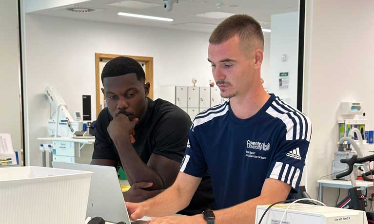 Ephron Mason-Clark and a Sport and Exercise Science student looking at a laptop computer