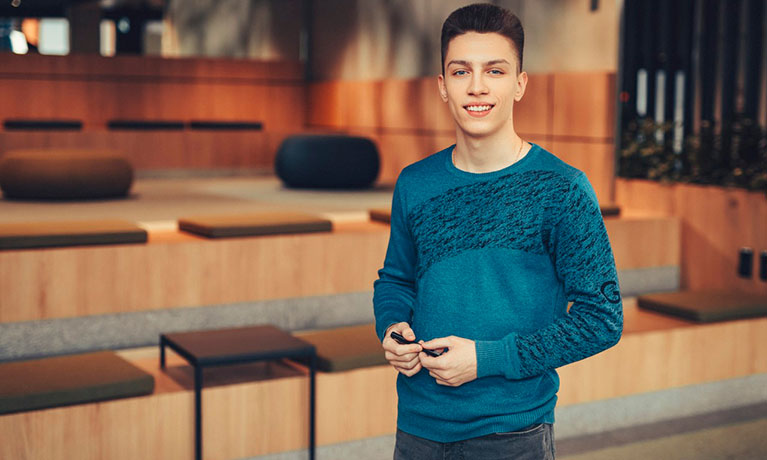 Student standing with lecture hall behind him