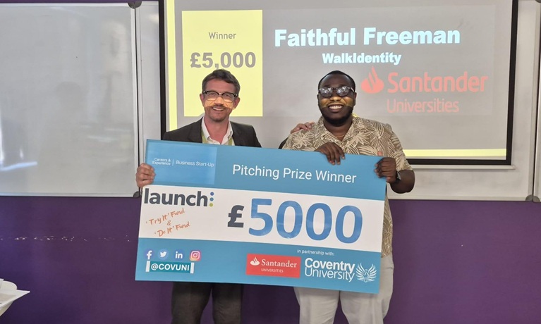 Two men holding a cheque for £5,000