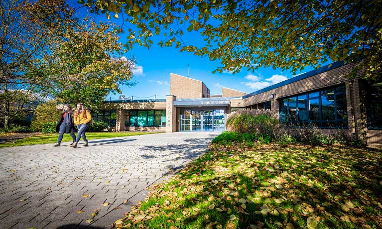 Jaguar Building in the sun with students walking