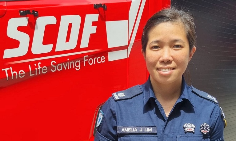 A female officer standing at the door of a fire engine