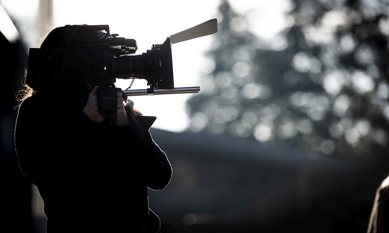 A student holding a video camera