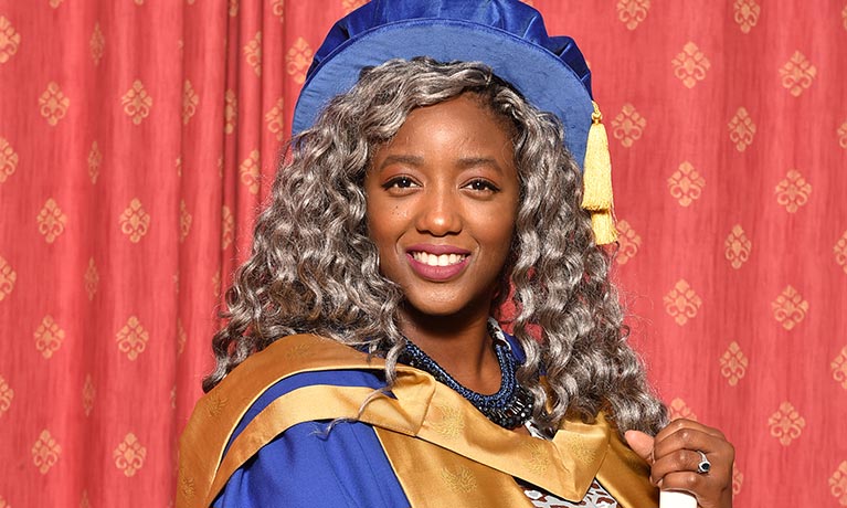 Woman in ceremonial robes holding certificate