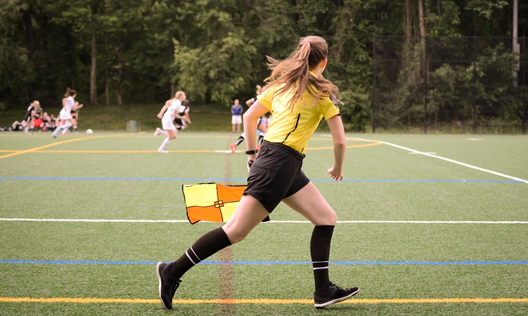 A young person officiating at a football match