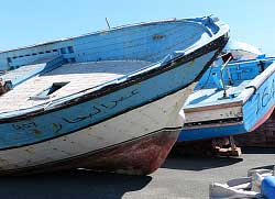 A close up of two boats hulls moored on a sand bank in low tide