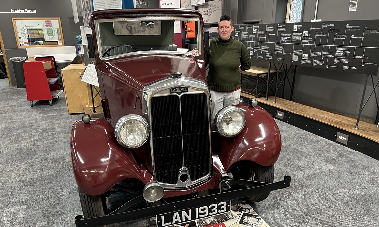 Siân Hewitt, Coventry University Group Archives and Records Manager, stood next to a 1931 Lanchester 15/18 motorcar,