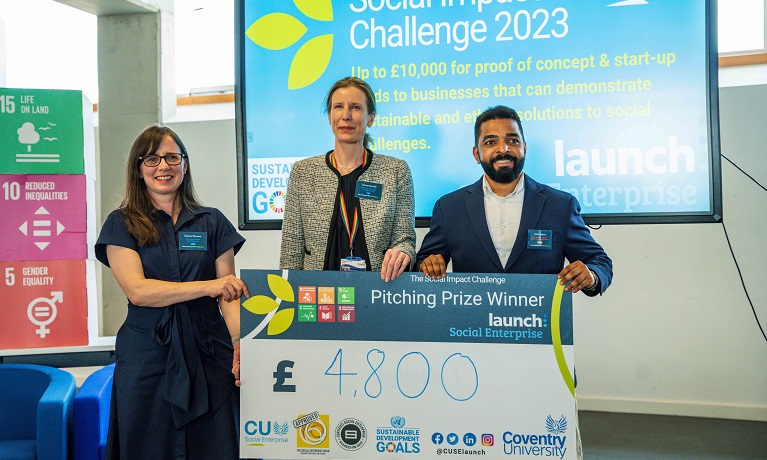 Two women and a man holding a large cheque for £4,800